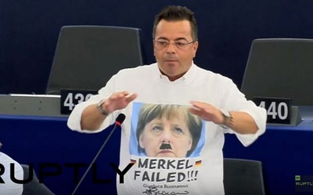 Italian MEP Gianluca Buonanno wearing a T-shirt bearing a mashed up image of German Chancellor Angela Merkel and Adolf Hitler on October 6, 2015. (screen shot: YouTube)