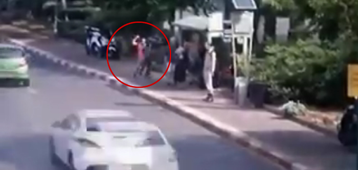 Still image from footage showing a knife-wielding terrorist (circled) stabbing Israelis as they wait at a bus stop on Jerusalem Boulevard in Ra'anana on October 12, 2015. (screen capture)