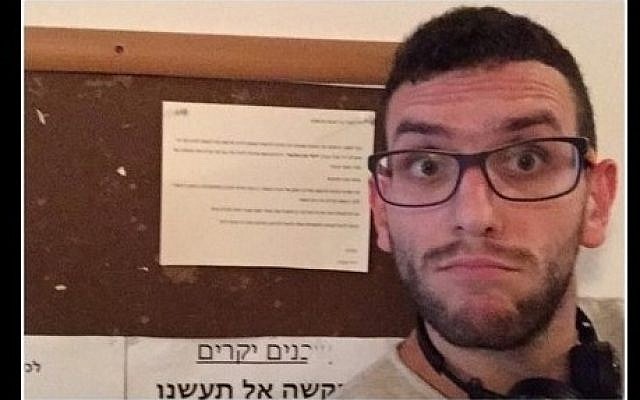 An Arab resident of Tel Aviv takes a selfie in front of an anti-Arab notice hung in his building's stairwell on October 12, 2015. (Screen shot: Facebook)