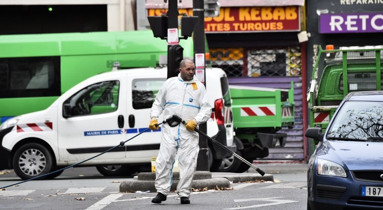 A crime scene cleaner is pictured at the Rue de Charonne in Paris on November 14, 2015, following a series of coordinated attacks in and around Paris late Friday that left at least 127 people dead. (AFP PHOTO/LOIC VENANCE)