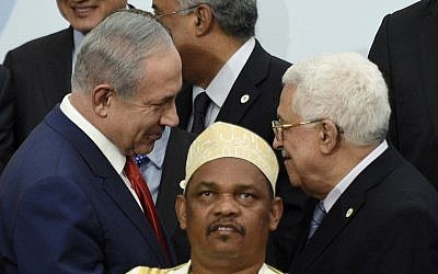 Prime Minister Benjamin Netanyahu (L) talks with Palestinian Authority President Mahmoud Abbas (R) behind Comoros' President Ikililou Dhoinine during the family photo during the COP21, United Nations Climate Change Conference, in Le Bourget, outside Paris, on November 30, 2015 (AFP PHOTO / POOL / MARTIN BUREAU)
