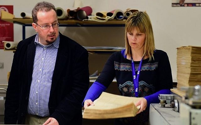 Director of Budapest City Archives, Istvan Kenyeres left, and chief-restorer Adrienn P.Holl stand next to documents dating from 1944 that are part of around 6,300 census forms of Budapest's then Jewish population in Budapest, November 12, 2015. (AFP PHOTO/ATTILA KISBENEDEK)