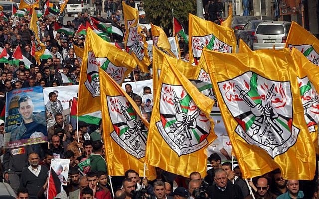 Palestinian demonstrators hold Fatah party flags as they demonstrate in the center of the West Bank city of Hebron on November 4, 2015. (AFP/HAZEM BADER)