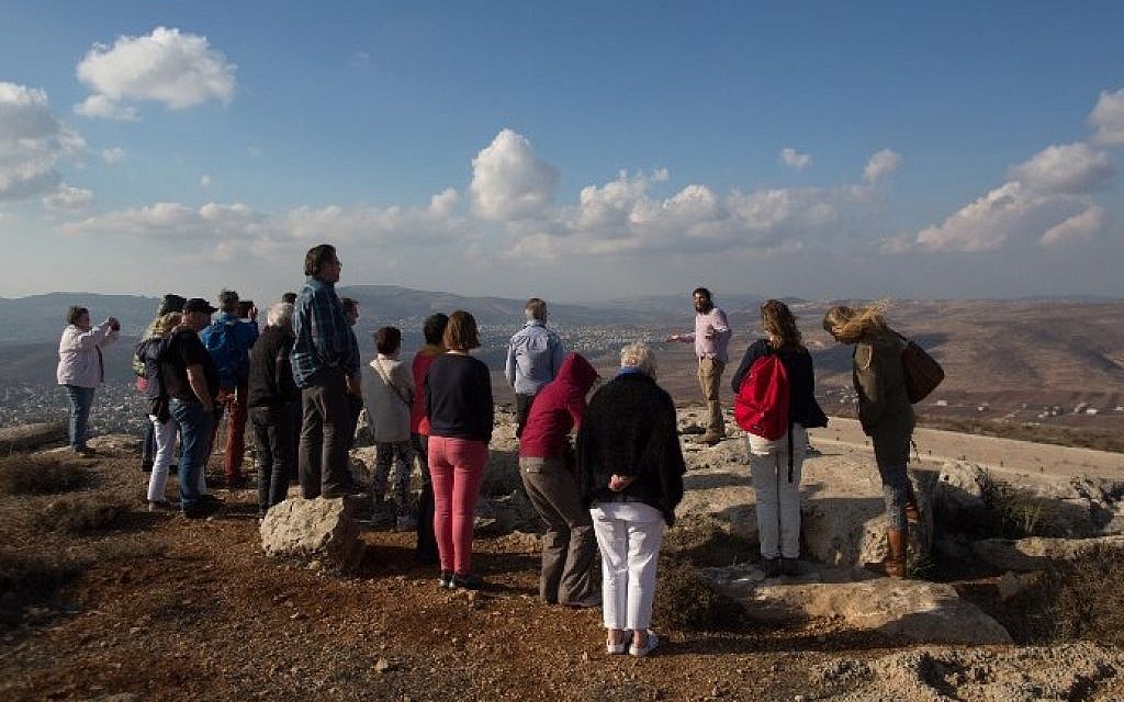 Nati Rom, chairman of Lev Haolam foundation, guides a group European Christians during a tour of the Israeli outpost of Esh Kodesh in the West Bank on November 10, 2015. (Menahem Kahana/AFP)