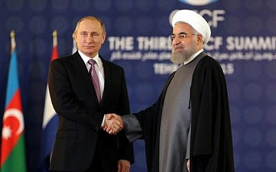 Iranian President Hassan Rouhani shakes hands with his Russian counterpart Vladimir Putin during the Gas Exporting Countries Forum (GECF) summit in Tehran on November 23, 2015. (AFP PHOTO / ATTA KENARE)