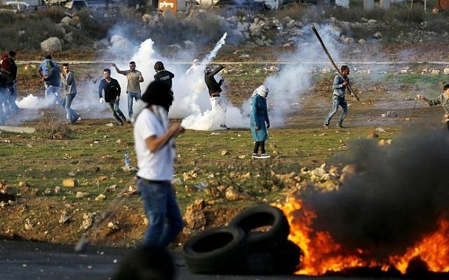 Palestinian demonstrators hurl rocks at Israeli security forces during clashes in al-Bireh on the outskirts of Ramallah in the West Bank, on November 29, 2015.  (AFP/Abbas Momani)