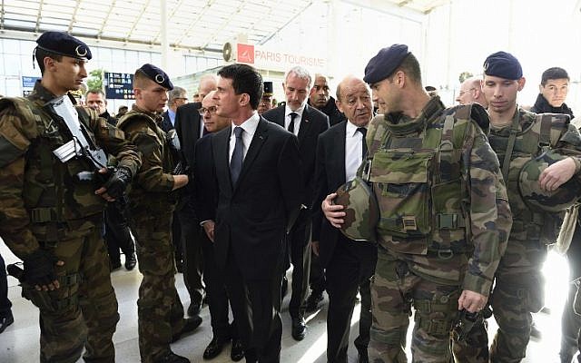 French Prime minister Manuel Valls, center, arrives with French Defense minister Jean-Yves Le Drian and other officials at the Gare du Nord railway station in Paris on November 15, 2015, to speak with SNCF staff about security measures following a series of coordinated attacks in and around Paris on November 13. (AFP/ERIC FEFERBERG)