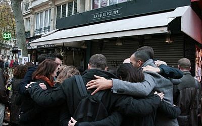 People gather in front of a makeshift memorial in tribute to the victims of the Paris attacks, on November 15, 2015 at the La Belle Equipe rue de Charonne, 11th arrondissement, of the French capital. (AFP PHOTO / JACQUES DEMARTHON)