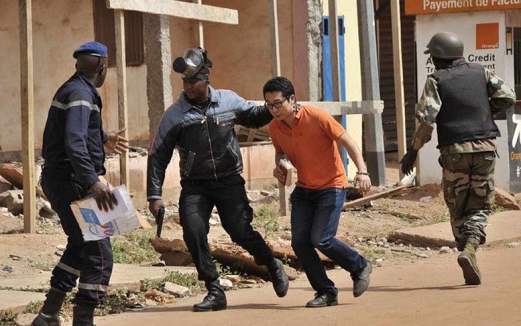 Malian security forces evacuate a man from an area surrounding the Radisson Blu Hotel in Bamako on November 20, 2015. (AFP/Habibou Kouyate)