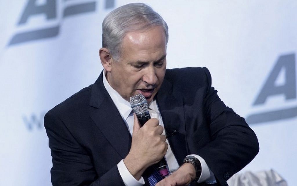Prime Minister Benjamin Netanyahu jokingly looks at his watch while speaking about peace in the Middle East at the National Building Museum November 9, 2015, in Washington, DC. (AFP/Brendan Smialowski)