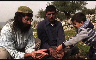 Muhammad Ziad Sabateen, right, as a young child plays with his father Ziad Sabateen, center, and Jewish peace activist Shaul Judelman from the 'Shorashim -- Judur -- Roots' organization. (Courtesy)