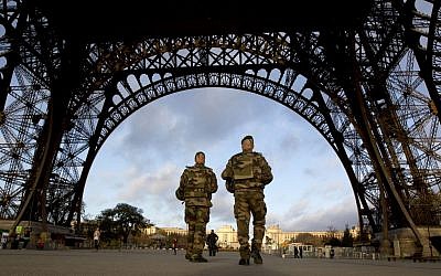 French soldiers patrol at the Eiffel Tower which remained closed on the first of three days of national mourning in Paris, Sunday, Nov. 15, 2015. (AP/Peter Dejong)