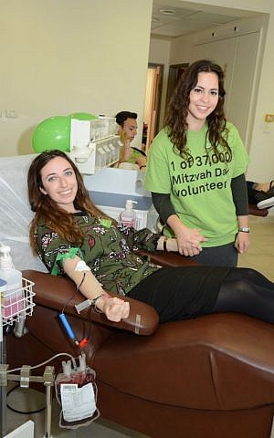 Emilie Maurer and Sara Ellerman give blood as part of the Mitzvah Day/MDA project in Israel on November 22, 2015. (courtesy)