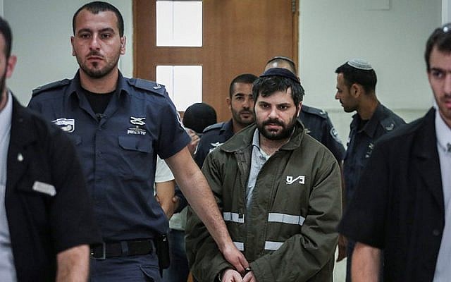 Police escort Yosef Ben David (in green), one of the Jewish suspects in the murder of Muhammed Abu Khdeir, in the Jerusalem District Court on June 8, 2015. (Hadas Parush/Flash90)