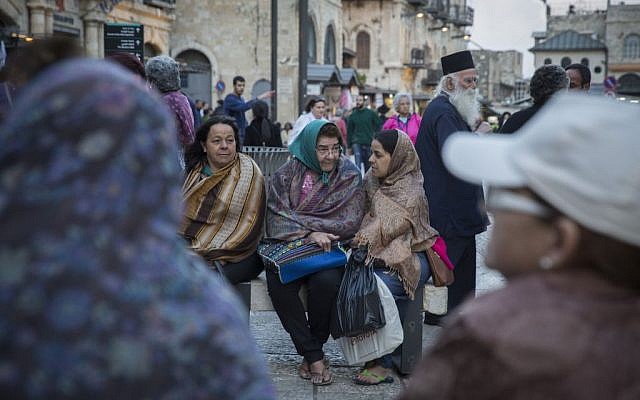 Tourists cover themselves in scarves as they wait for their group at Jaffa Gate in Jerusalem's Old City, as tempratures begin to drop and winter sets in, October 28, 2015. (Hadas Parush/Flash90)