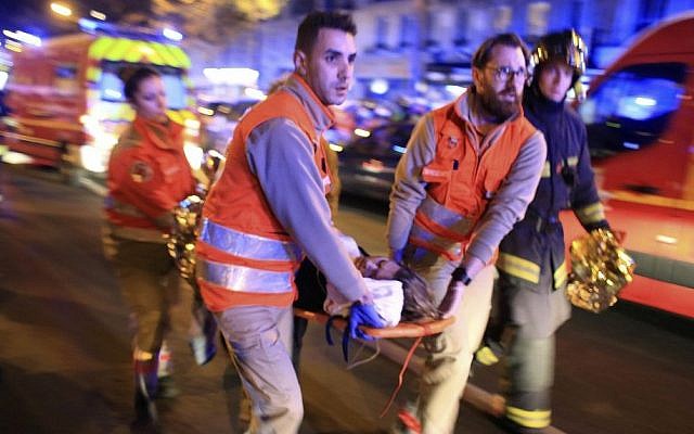 A woman is evacuated from the Bataclan concert hall after a terrorist shooting attack in Paris, November 13, 2015. (AP Photo/Thibault Camus, File)