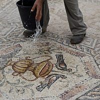 An employee of Israel’s antiquities authority works on a 1,700-year-old Roman-era mosaic floor in Lod, Israel, Monday, Nov. 16, 2015. Archaeologists found the mosaic last year while building a visitors’ center meant to display another mosaic, discovered two decades earlier at the same spot. The authority said the newly discovered Roman-era mosaic measures 11 meters by 13 meters (36 feet by 42 feet) and paved the courtyard of a villa in an affluent neighborhood that stood during the Roman and Byzantine eras. (AP Photo/Ariel Schalit)