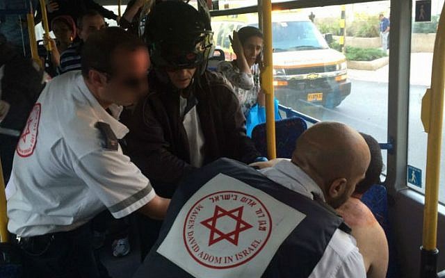 Magen David Adom medics treat an Israeli in his 40s on a bus in Rishon Lezion shortly after the man was stabbed by a Palestinian from Hebron, November 2, 2015. (Eliran Avital/MDA)