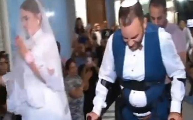 With the help of ReWalk Robotics, Dudu Shevy is able to walk down the aisle (screen capture: Channel 2)