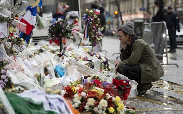 Drummer of the US rock group Eagles of Death metal Julian Dorio pays tribute to the victims of the November 13 Paris terrorist attacks at a makeshift memorial in front of the Bataclan concert hall in Paris on December 8, 2015. (Miguel Medina/AFP)