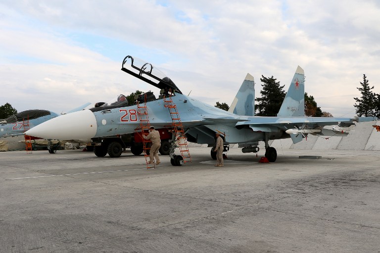 Russian servicemen prepare a Russian Sukhoi Su-30SM fighter jet before a departure for a mission at the Russian Hmeimim military base in Latakia province, in the northwest of Syria, on December 16, 2015. (AFP/Paul Gypteau)