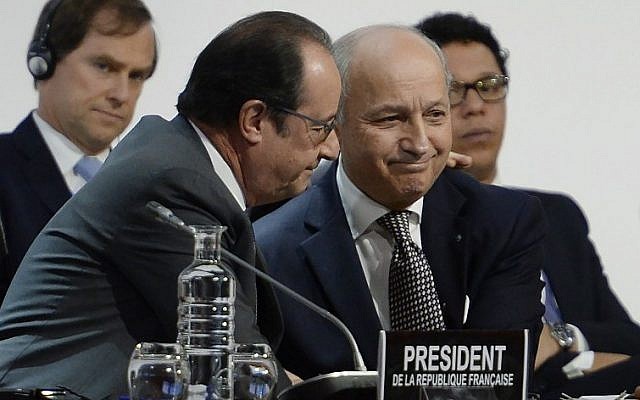 French Foreign Minister Laurent Fabius (R) is congratulated by French President Francois Hollande (L) after a statement at the COP21 Climate Conference in Le Bourget, north of Paris, on December 12, 2015. (AFP PHOTO/MIGUEL MEDINA)