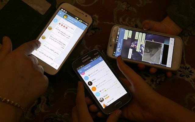 Iranians display their smartphones using the Telegram messenger application on December 1, 2015. (AFP Photo/Atta Kenare)