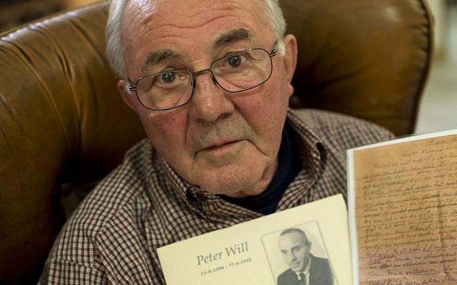 Joop Will holds a picture of his father Peter and a copy of the letter his father wrote during WWII as he poses for a portrait in Lelystad, Netherlands, Friday, Nov. 13, 2015. (Peter Dejong/AP Photo)