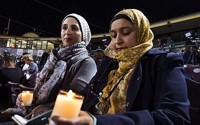 Rania Elbanna, 40, left, and Dr. Shaheen Zakaria, friends from Loma Linda, California, hold candles at a vigil at San Manuel Stadium Thursday, Dec. 3, 2015, in remembrance of the 14 people lost Wednesday in the San Bernardino mass shooting. (Tom Tingle/The Arizona Republic via AP) 