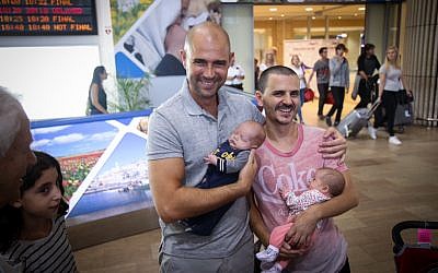 Likud party politician Amir Ohana (left) and his partner seen at Ben Gurion International Airport as they arrive back from the US with their surrogate babies, on September 26, 2015. (Flash90)