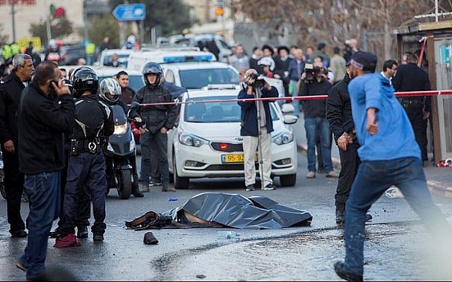 The body of a Palestinian terrorist lies in the road after he was shot dead by Israeli security personnel during a terror attack at the entrance to Jerusalem on December 14, 2015, that injured 14 people, including a baby. (Photo by Yonatan Sindel/Flash90)