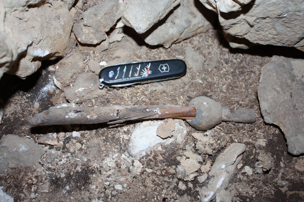 Archaeologists discover the first lead object used in the Middle East in a cave south of Beersheba. A pocket knife next to the scene provides scale. (Boaz Langford and Micka Ullman)