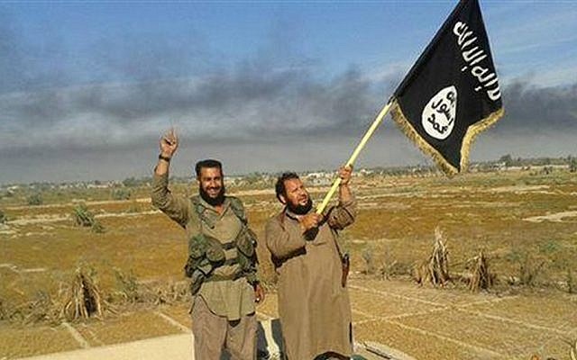 Illustrative photo of Islamic State militants, with an IS fighter waving the group flag in Fallujah, Iraq, west of Baghdad, June 28, 2015. (Militant website of IS, via AP)
