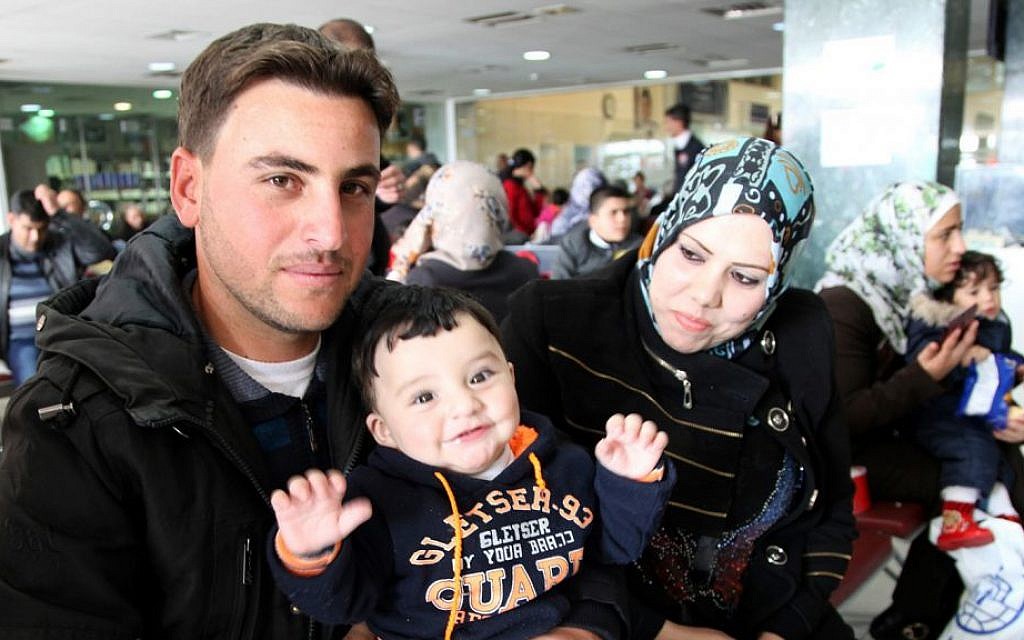 Radi poses for a photo with his son and wife, whose names are omitted for security reasons, while waiting in an airport in Amman, Jordan, to board a plane to Canada where they will be resettled, December 20, 2015. (AP/Sam McNeil)