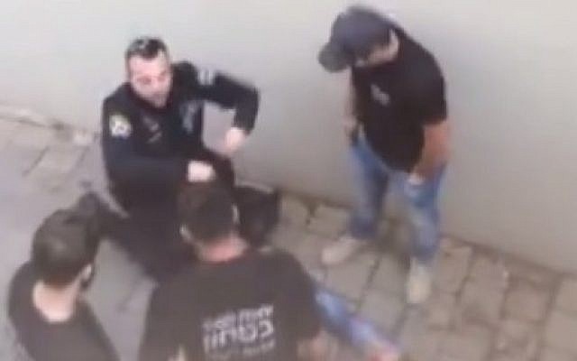 Police officers stand over Mahmoud Faisal Bisharat, a Palestinian who entered Israel illegally and stabbed three people in Ra'anana on December 19, 2015. (Screen capture: Facebook)