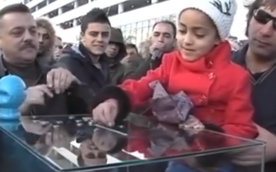 Palestinian girl donates to house rebuilding campaign in Nablus on Dec. 6, 2015 (screen capture: Palestinian Authority TV) 