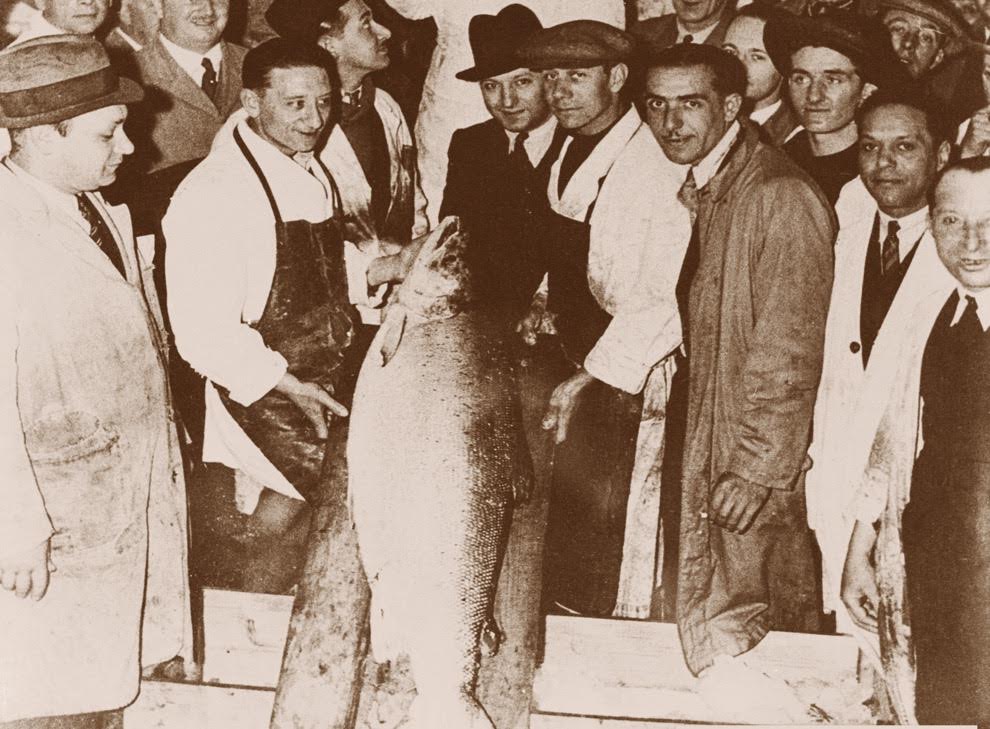 An archive photo from 1935 shows the largest salmon (74 pounds) ever sold at Billingsgate Fish Market in London. In the center, wearing a black homburg hat, is Louis Forman, son of Harry Forman, founder of the company. (courtesy)