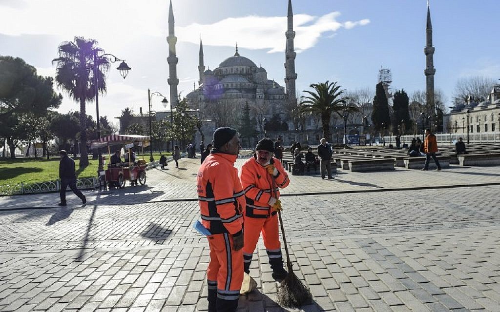 Municipal workers clean outside the Blue Mosque near the site of a blast in Istanbul's tourist hub of Sultanahmet on January 12, 2016. (AFP/BULENT KILIC)