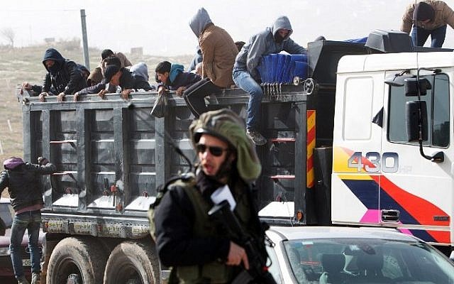 Palestinian workers being transported out of the Tekoa settlement south of Jerusalem on January 18, 2016 following a stabbing attack. AFP / MENAHEM KAHANA)