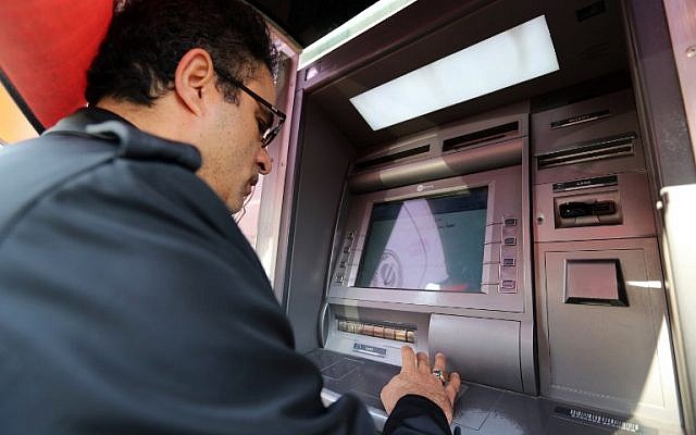 An Iranian man withdraws money from an ATM machine at a Bank Sepah in the capital Tehran on January 19, 2016. (AFP/Atta Kenare)