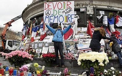 Jean-Baptiste Redde aka Voltuan holds up a banner that reads, "We must remember" following a remembrance rally attended by the President of France at Place de la Republique on January 10, 2016 in Paris, France (AFP PHOTO / DOMINIQUE FAGET)