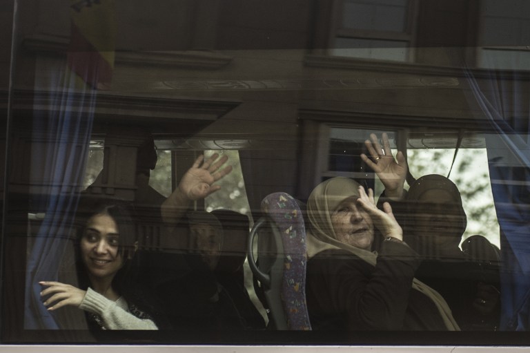 Israeli tourists wave from a bus as they leave the Three Pyramids hotel in Cairo's al-Harm district on January 7, 2016. (AFP Photo/ Khaled Desouki)