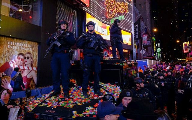 New York police officers stand guard amid airborne confetti during New Year's Eve celebrations at Times Square on January 1, 2016 in New York City. (Eduardo Munoz Alvarez/Getty Images/AFP)