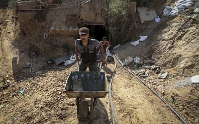 File: Palestinian men work at the entrance of a tunnel used for smuggling supplies between Egypt and the Gaza Strip after being flooded with seawater by the Egyptian army, in Rafah in southern Gaza on October 1, 2015. (Abed Rahim Khatib/ Flash90)