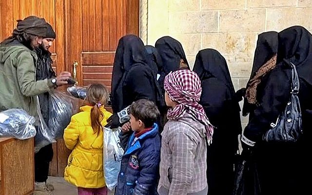 Members of the Islamic State group distribute niqabs and veils to Iraqi women in Mosul, northern Iraq, January 31, 2014. (Militant website via AP, File)