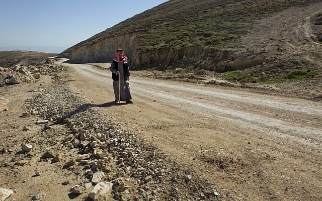 A Palestinian walks on a newly-made section of a road that was financed by the European Union, on the outskirts of the West Bank village of Taqoa, near Bethlehem, January. 16, 2016. (AP Photo/Nasser Nasser)