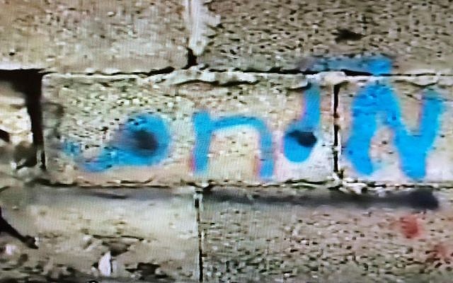 The Hebrew family name "Milhem" written in blue paint on the outside wall of the last building in which Tel Aviv killer Nashat Milhem hid out in Arara before he was cornered, chased and killed on January 8, 2016 (Channel 2 screenshot)