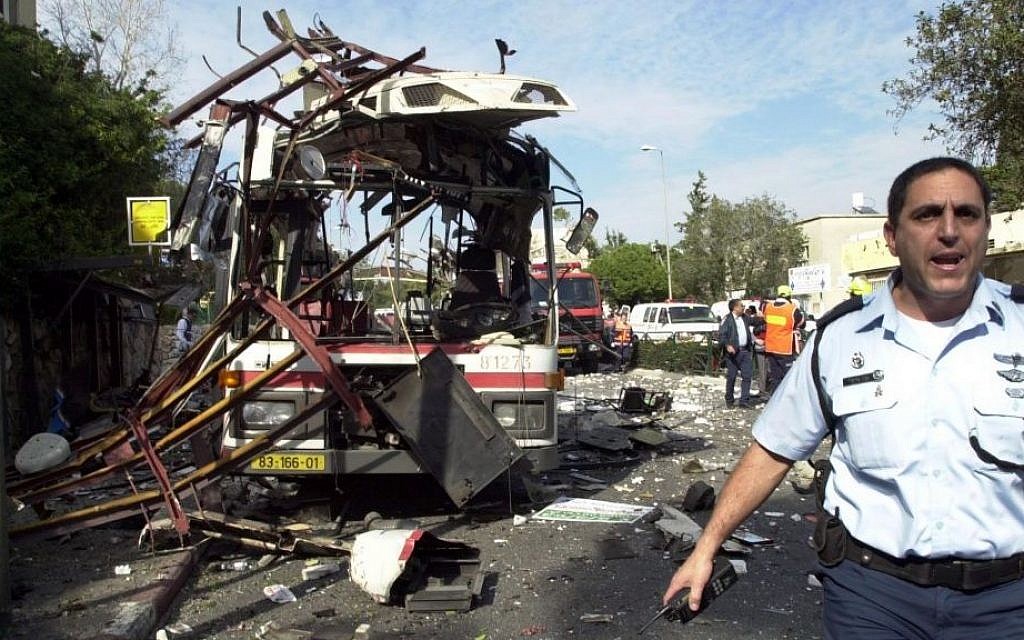 An Israeli police officer at the scene of a public bus bombing in the northern Israeli city of Haifa, Wednesday, March 5, 2003. A Palestinian suicide bomber blew himself up aboard the crowded bus, killing at least 17 people and injuring dozens. (Ronen Lidor/ Flash90)