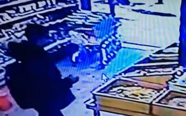 Security footage shows a suspected Arab Israeli gunman in a grocery on Dizengoff Street in Tel Aviv, seconds before he stepped outside and opened fire with a machine gun, killing two people, on January 1, 2016.  (screen capture)