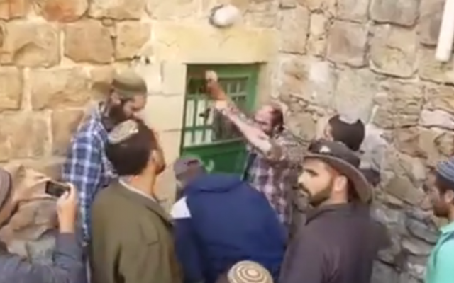 Settlers in Hebron force entry into several properties they claimed to have secretly bought on January 21, 2016 (screen capture: YouTube)